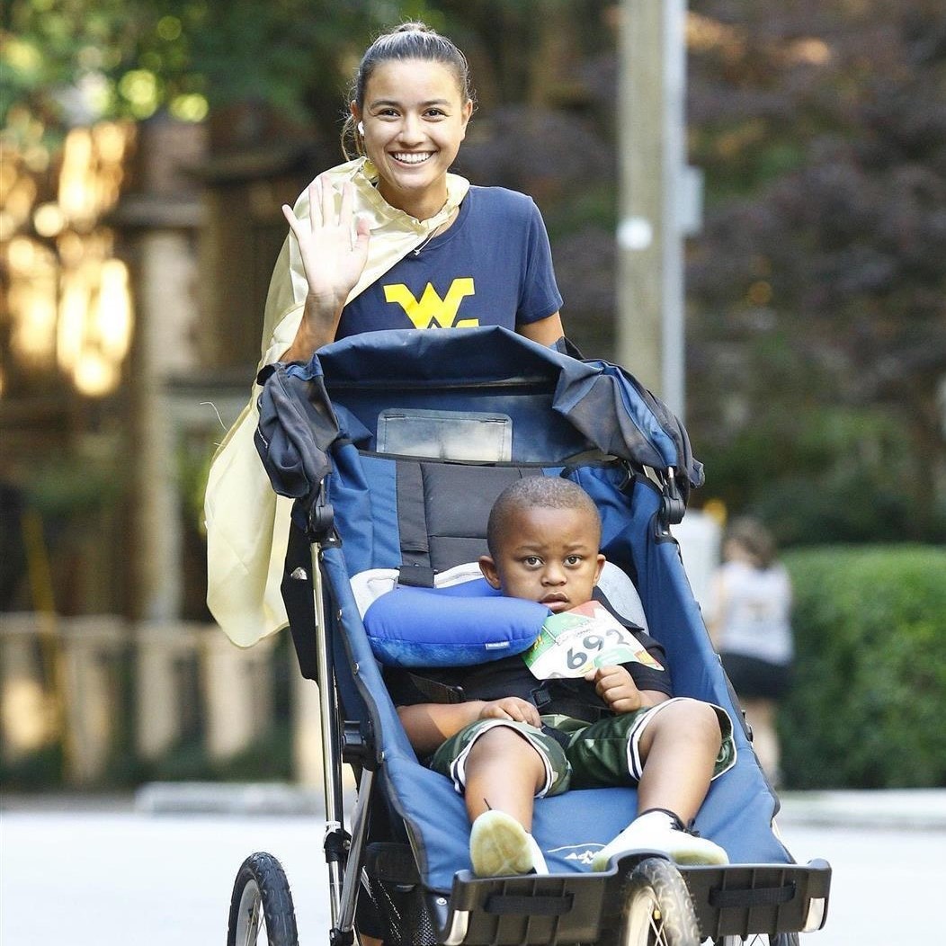 Mom pushes child in stroller during Superhero Sprint race